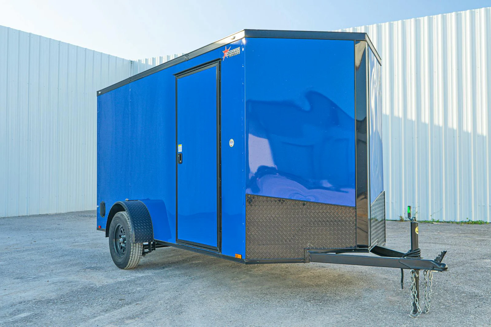 Blue enclosed cargo trailer with blackout package, front three-quarter view