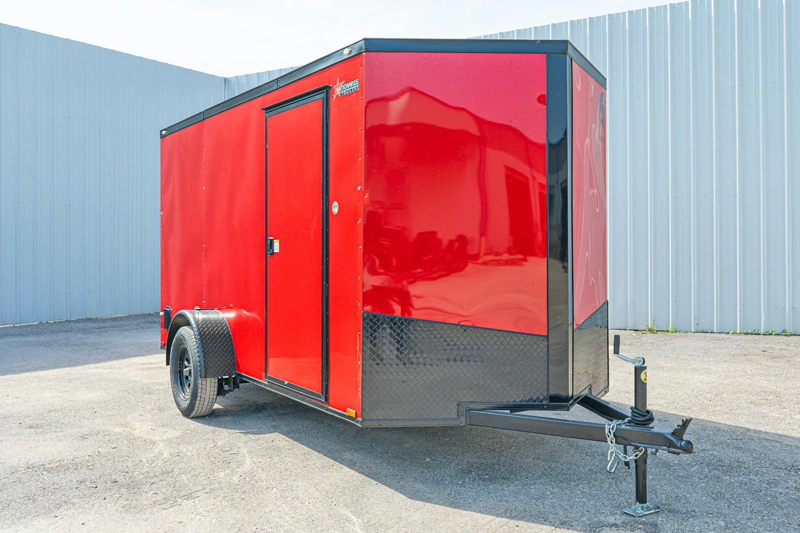 Red enclosed cargo trailer with blackout package, front three-quarter view