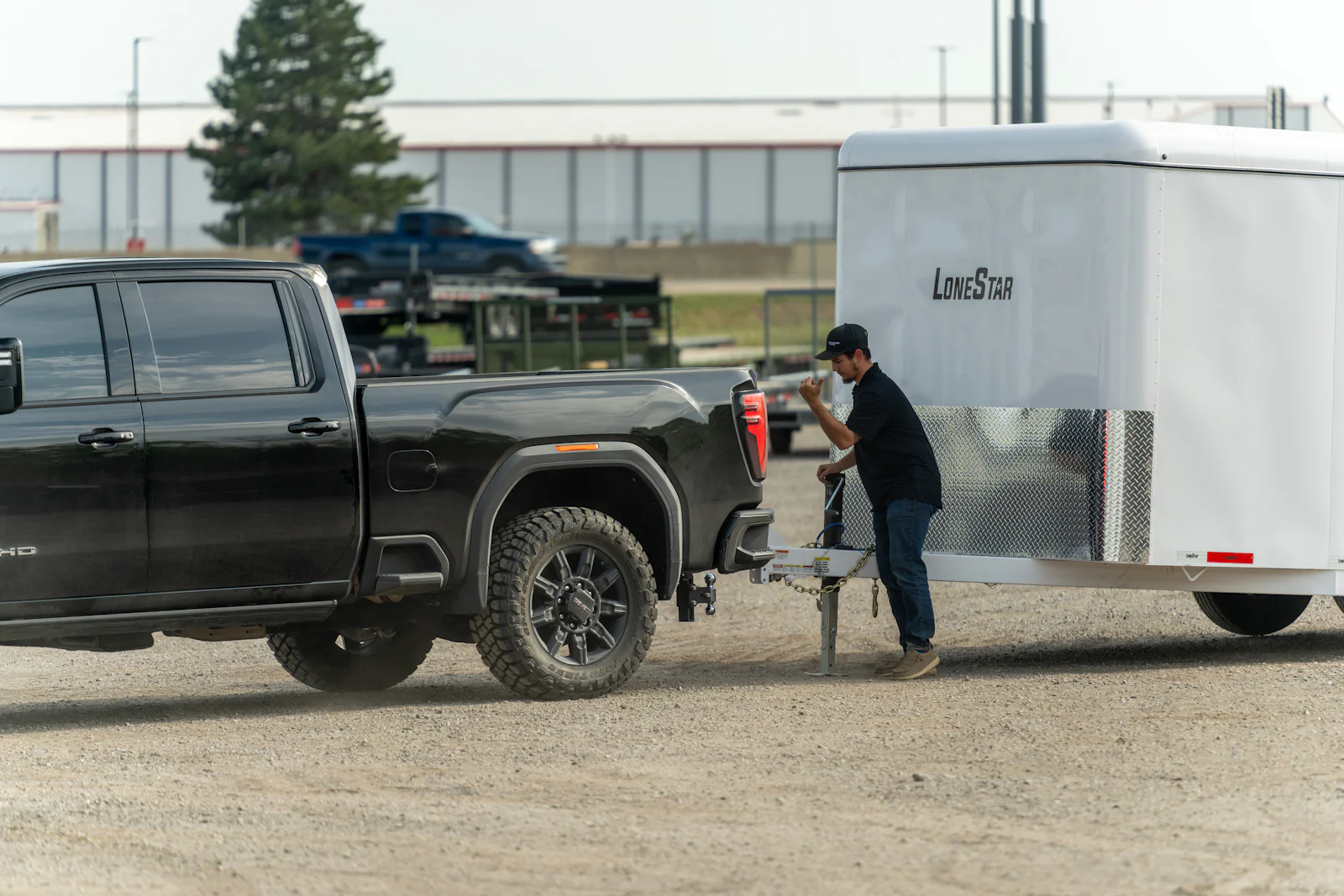 Customer hitching a new enclosed cargo trailer to his truck at a Nationwide Trailers lot