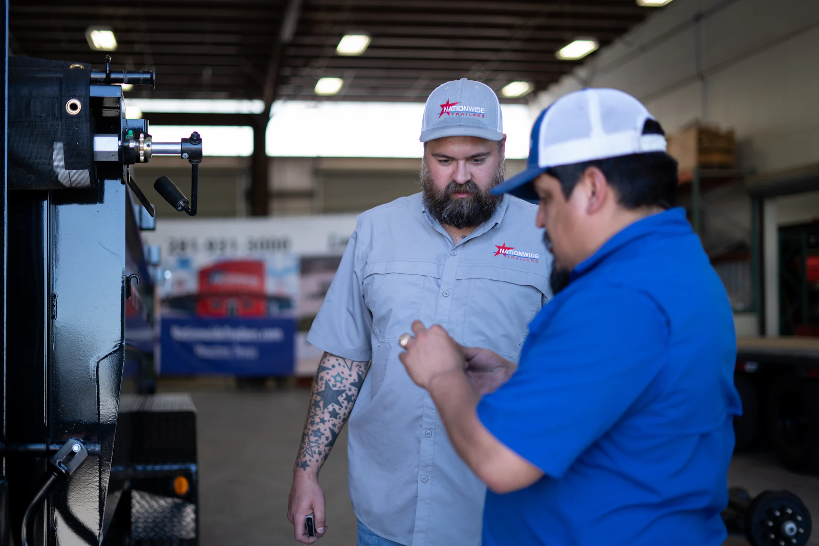 Service advisors reviewing trailer equipment in the shop