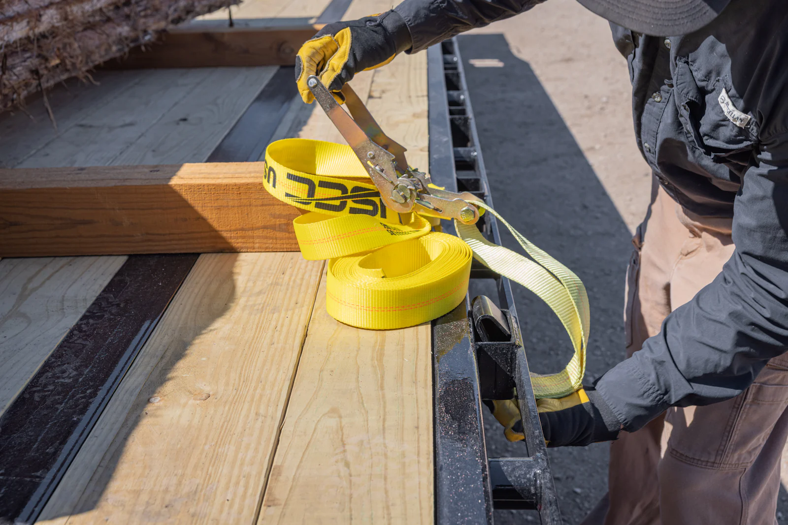 Securing equipment with straps on a gooseneck trailer