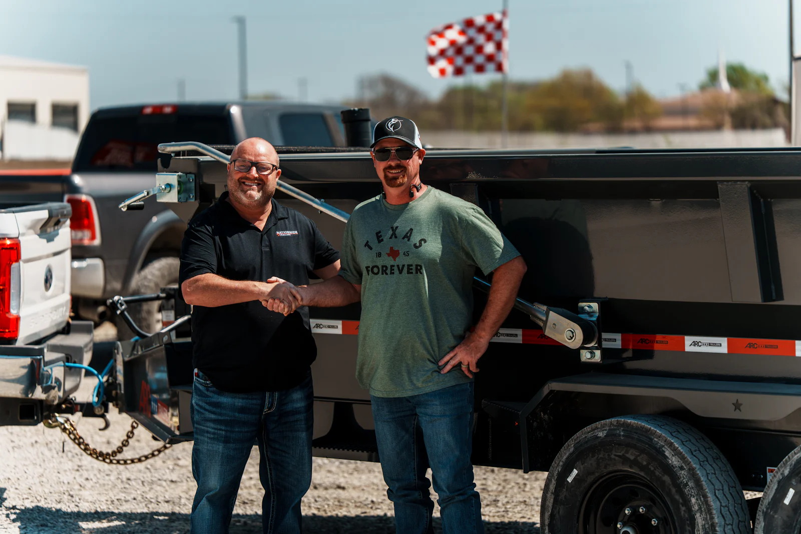 Welcome handshake in front of a new dump trailer