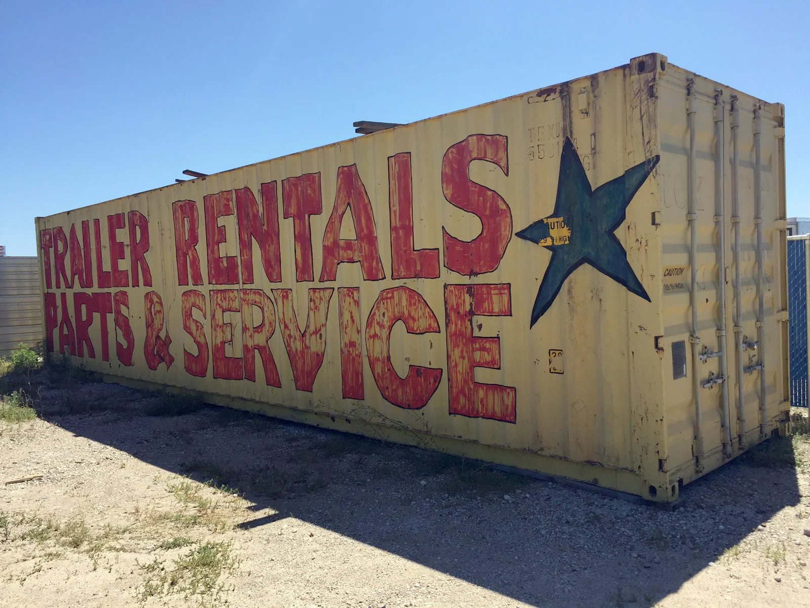 Hand-painted Trailer Rentals, Parts & Service sign on a shipping container at the first Nationwide Trailers lot