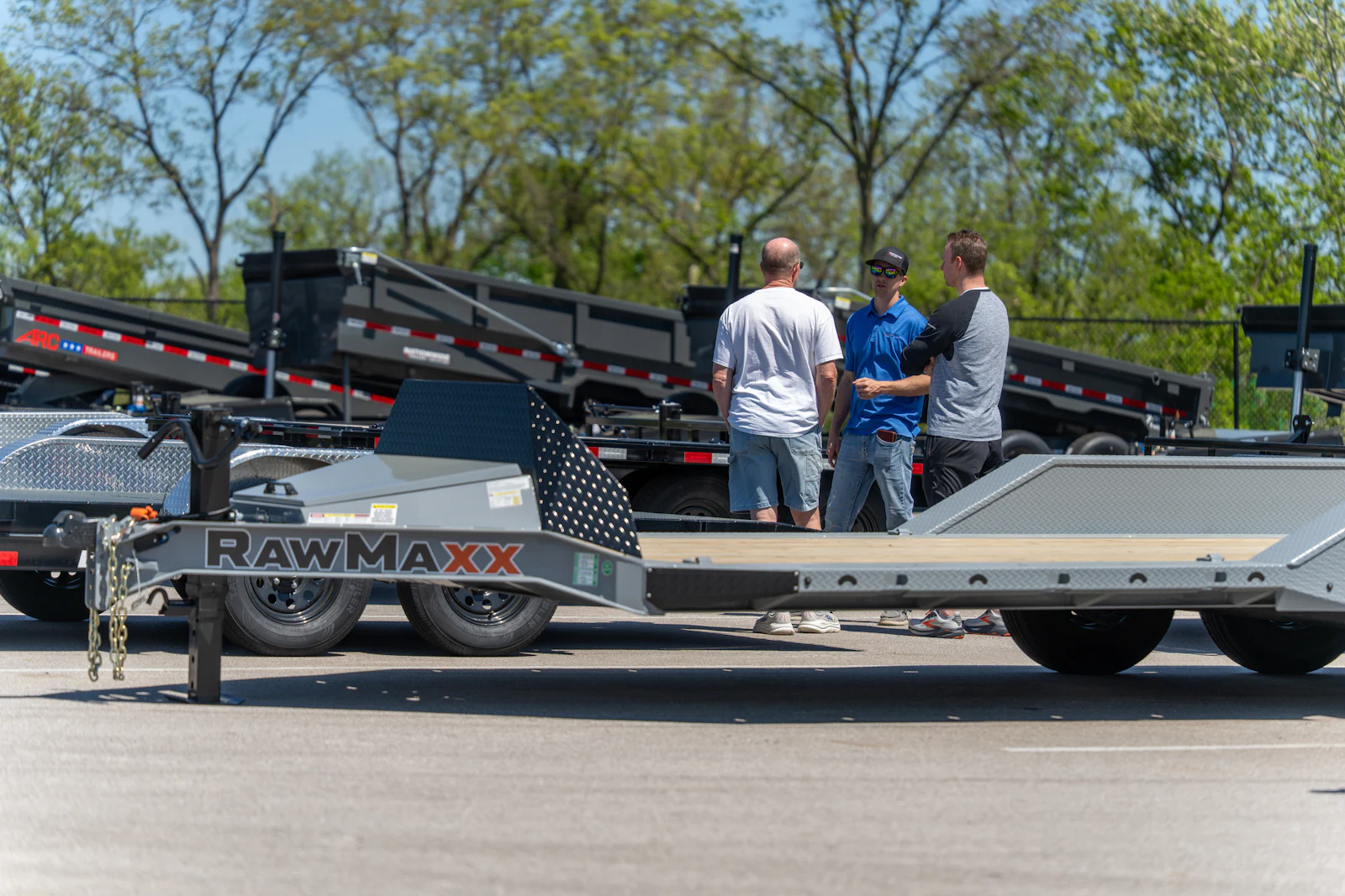 Sales advisor helping customers compare trailers on the lot