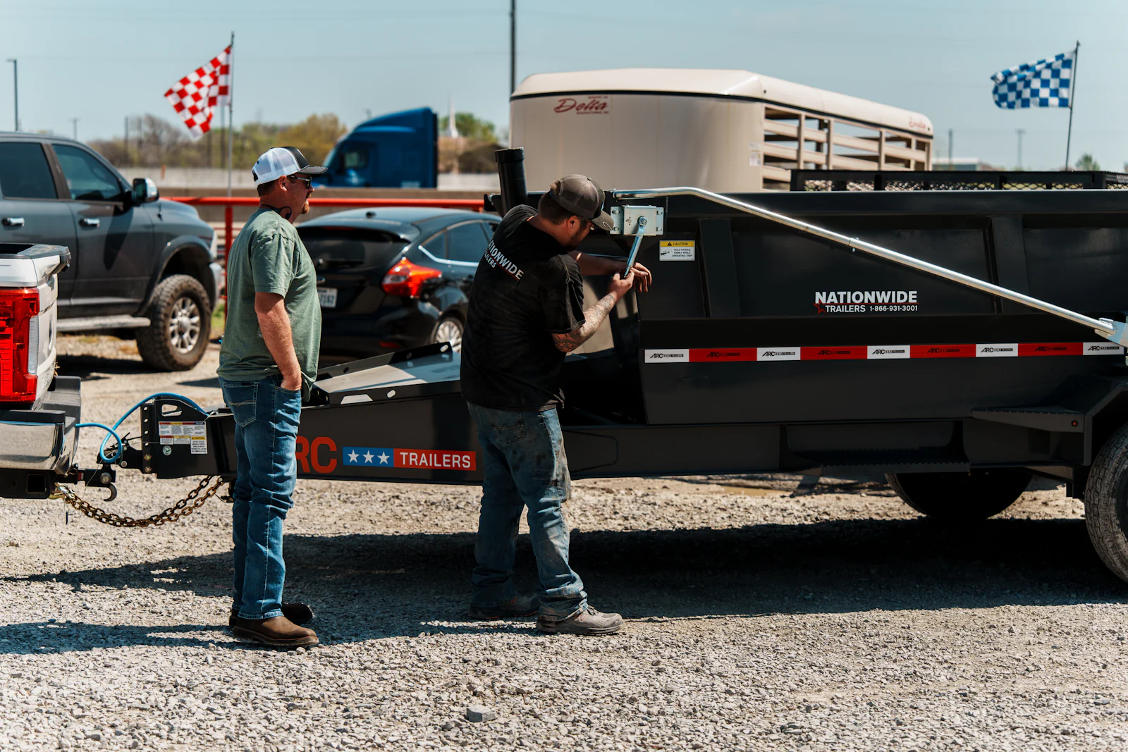 Nationwide Trailers technician inspecting a dump trailer's wheels and running gear